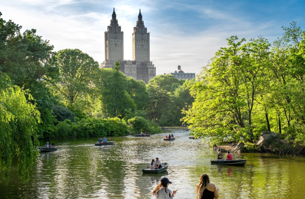 Central Park lake with row boats & view of San Remo Apartments in background