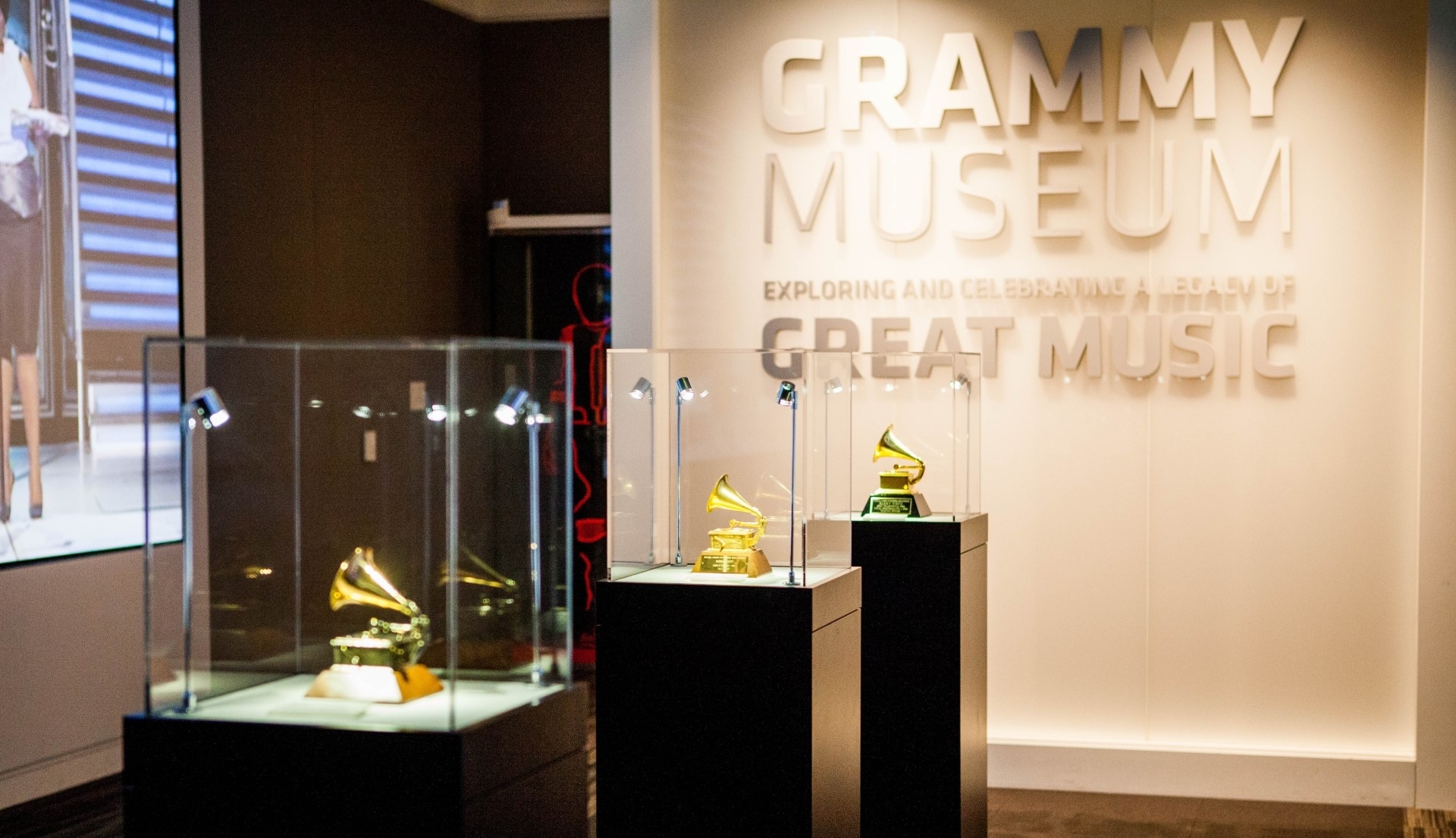 An exhibit inside the Los Angeles Grammy Museum showcasing iconic Grammy Award trophies.