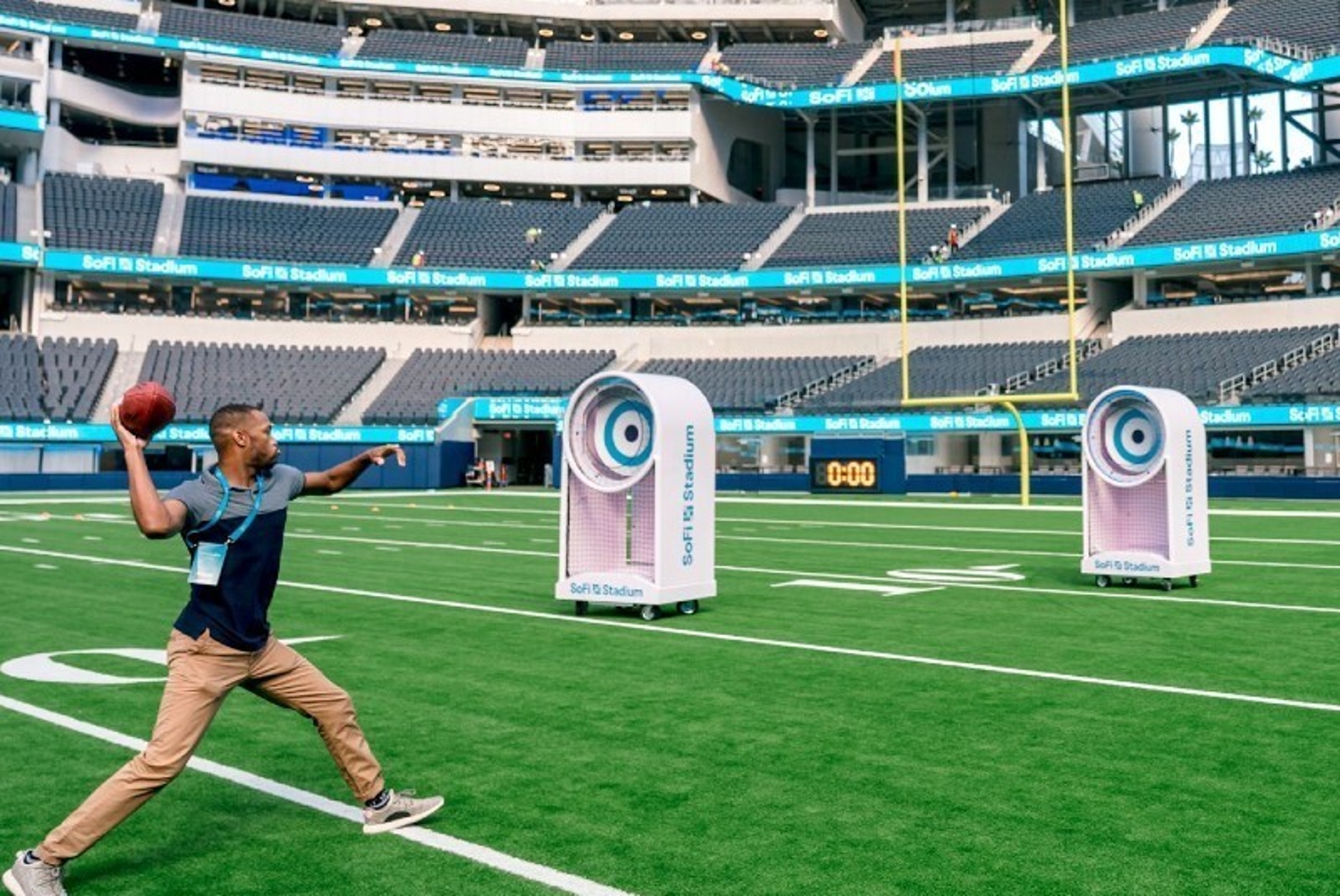 A person throws a football towards a target in a large, empty stadium in Los Angeles.