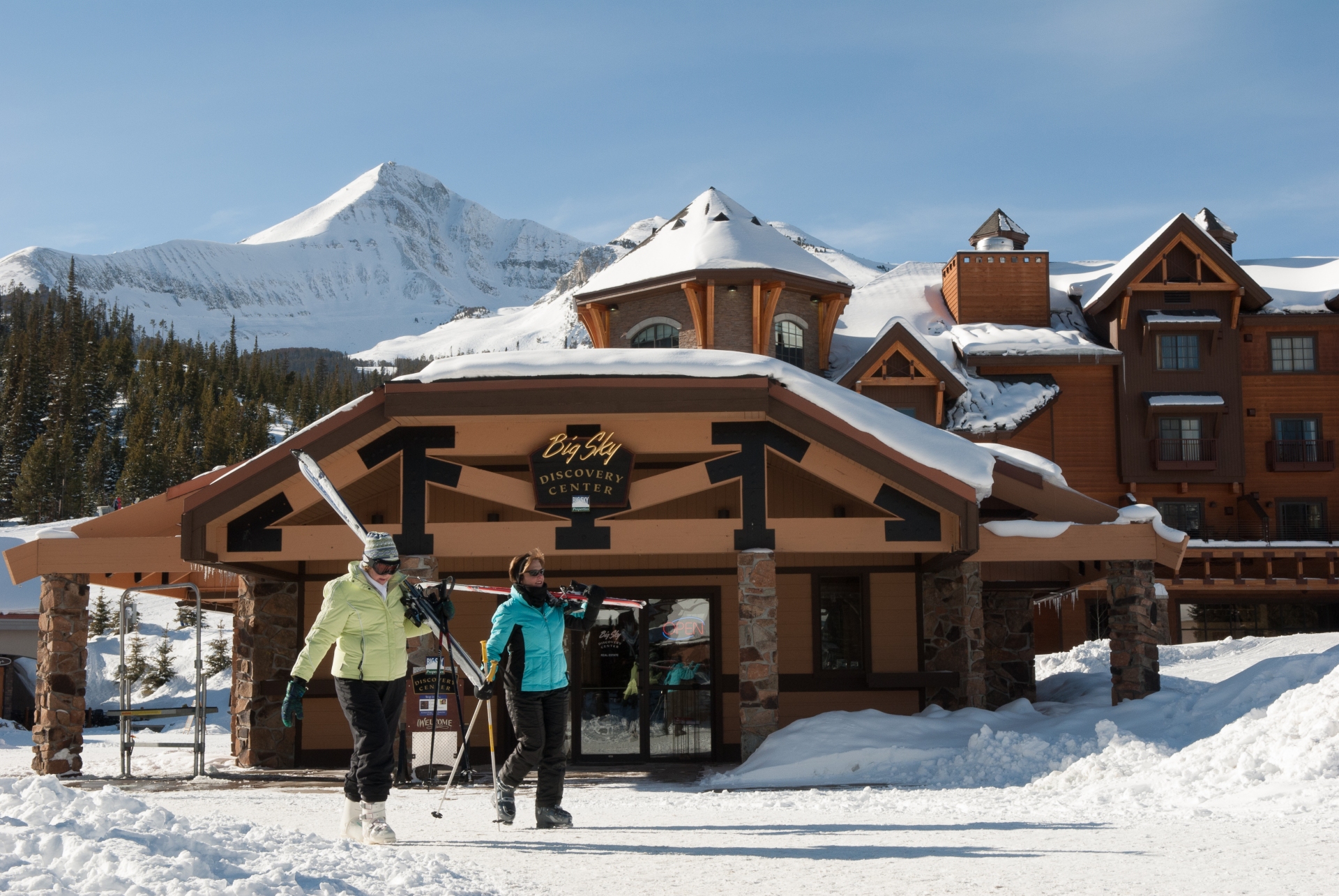 Big Key Resort Montana gorgeous luxury resort with 2 skiers walking past in the snow