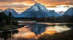 Grand Teton National Park stunning Grand Teton with the sunset reflecting in the lake with snow capped mountains in the distance