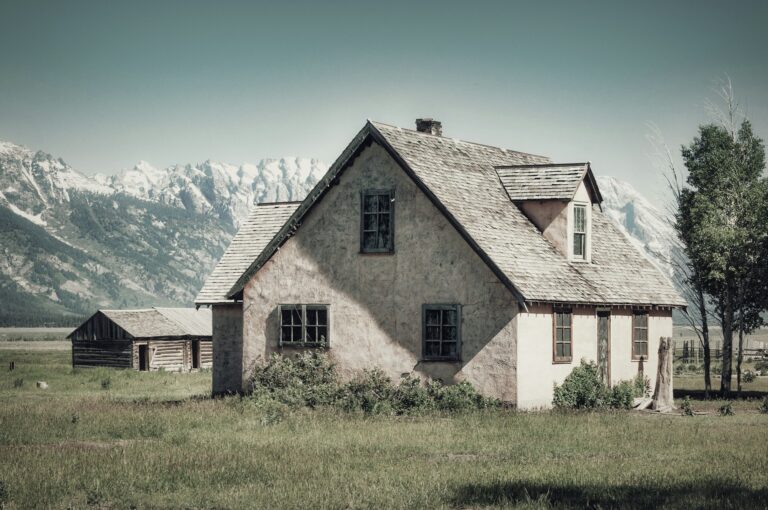 Grand Teton National Park, Wyoming with a gorgeous little house in the foreground with snow covered mountains in the distance