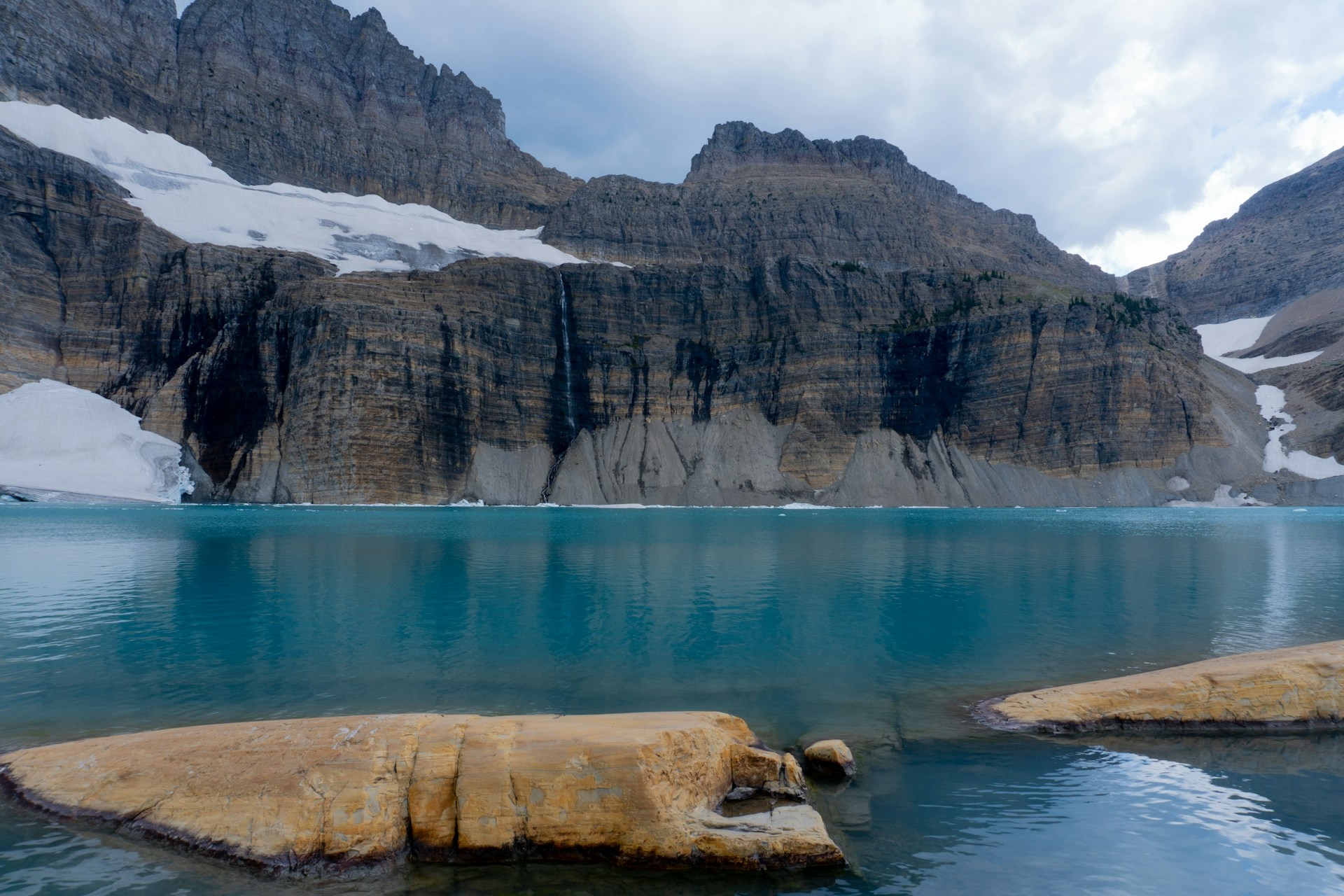 Grinnell Glacier, Montana stunning blue water with snow & rocks around