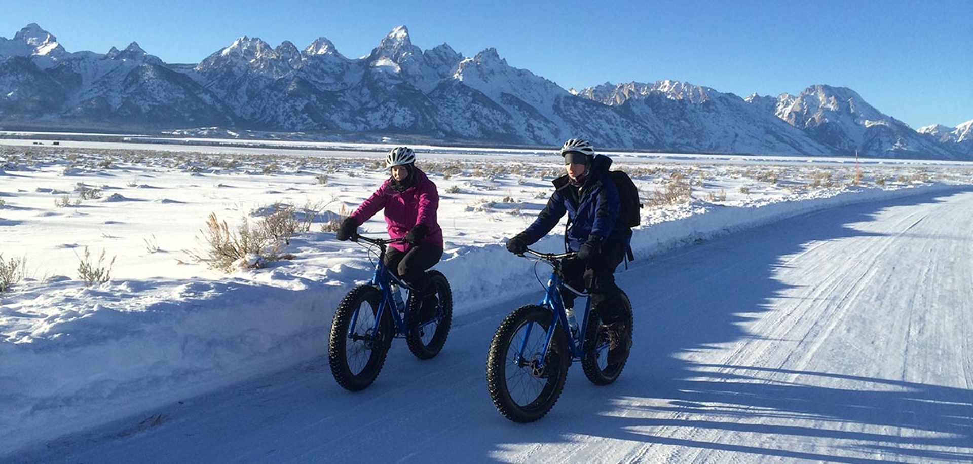 Jackson Hole Mountain Bike Rentals enjoying the scenery riding along the snow caped roads