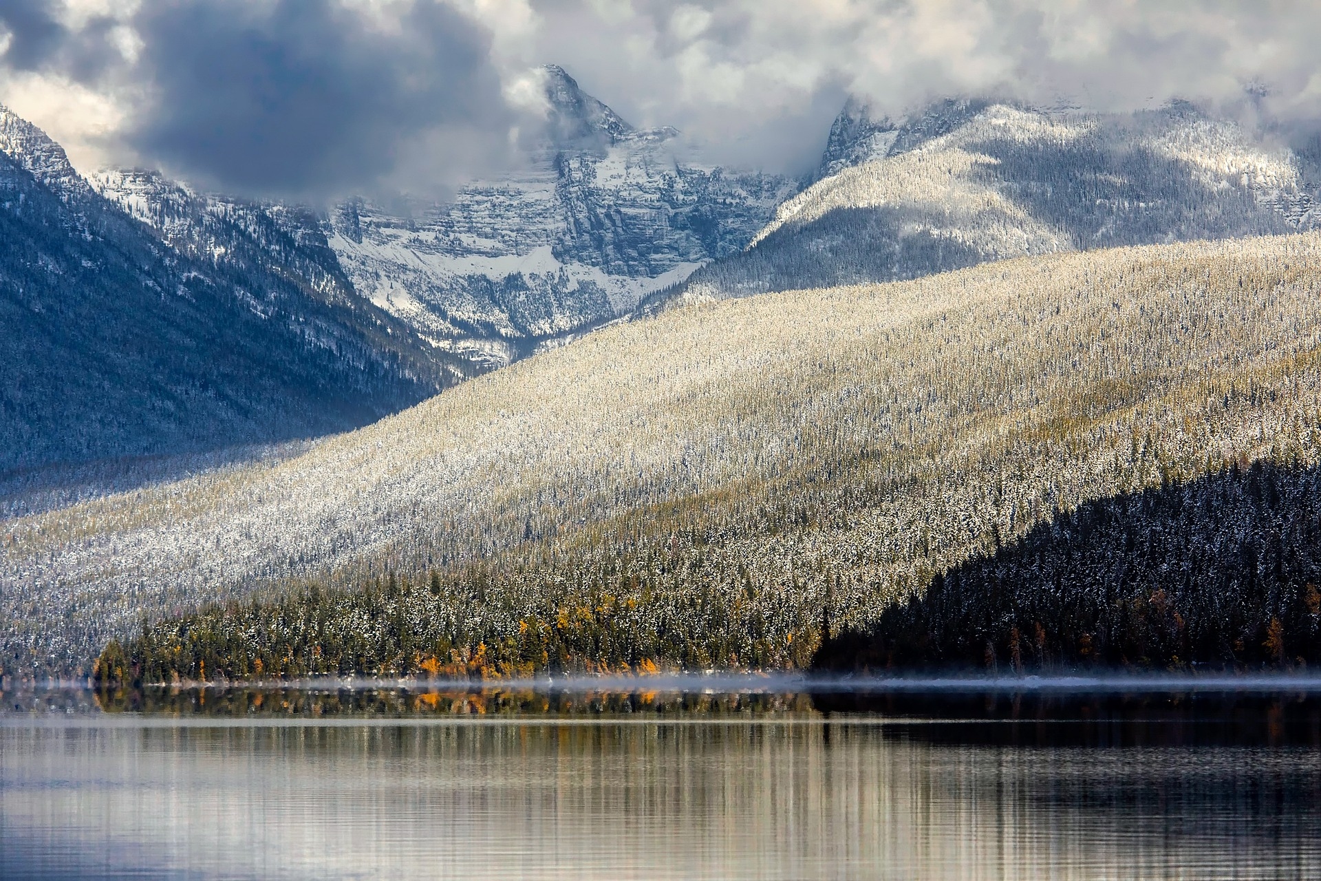 Lake McDonald Glacier National Park with colours of the snow on the trees in front of the mountains