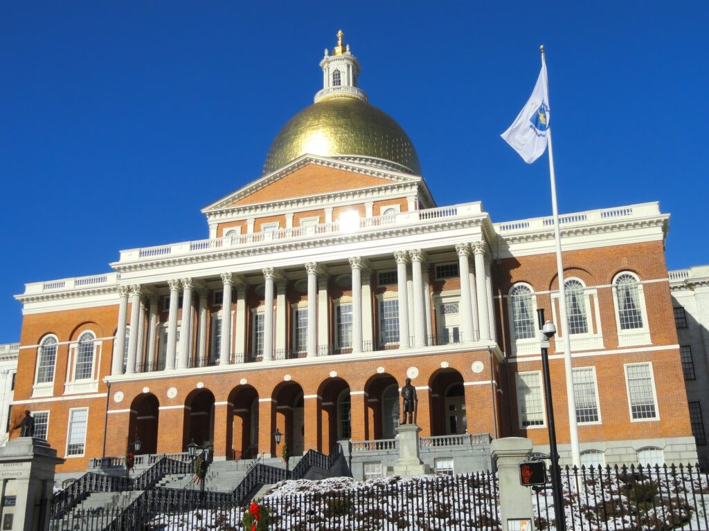 Boston State House on a clear summers day showing the front of the building and the sun shining off the gold dome at the top