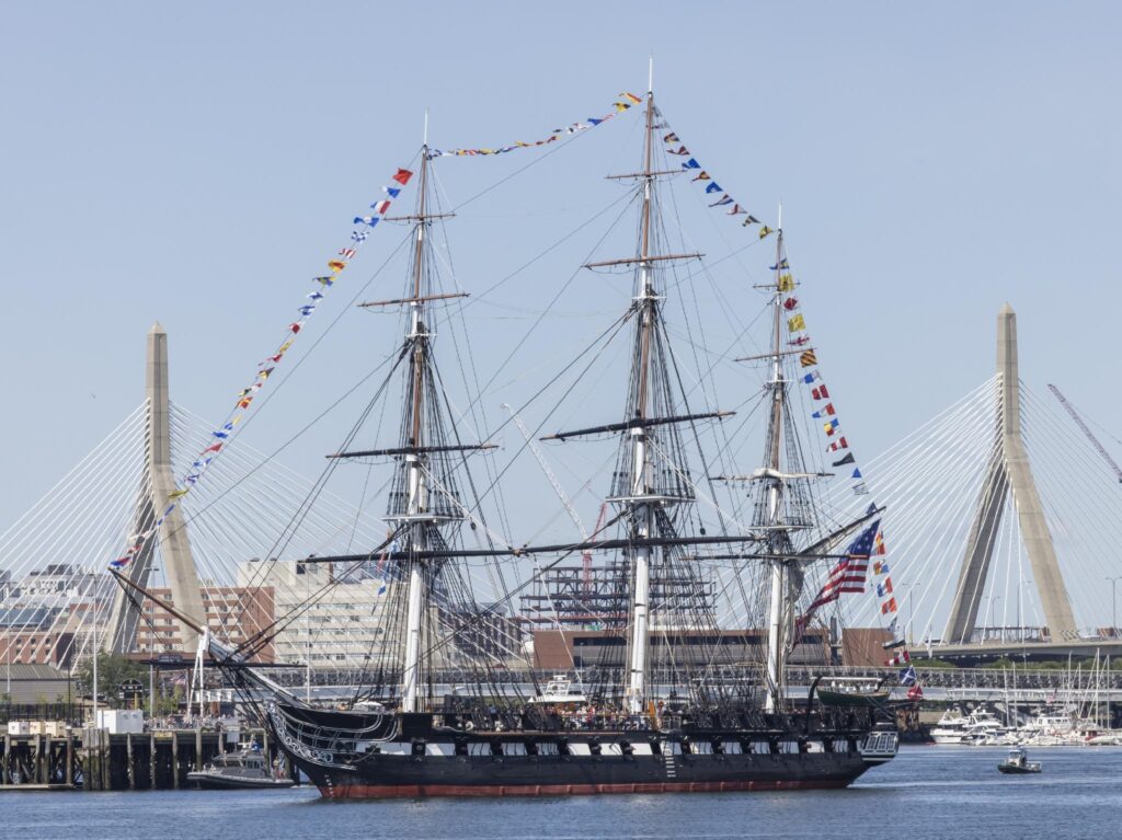 USS Constitution on a sunny day sailing in the close waters of Boston harbour