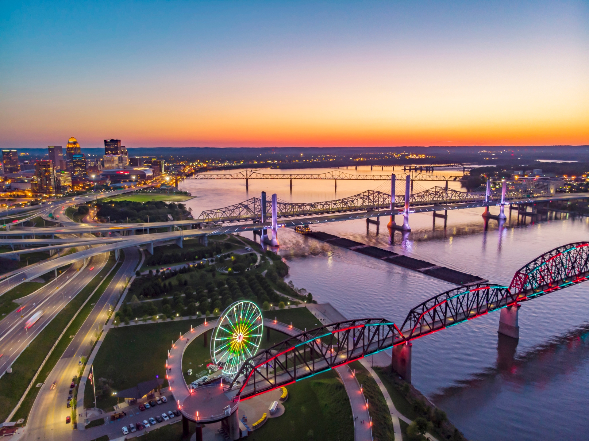 Louisville Big Four Bridge and Skyline with sunset in the background showing the downtown city park
