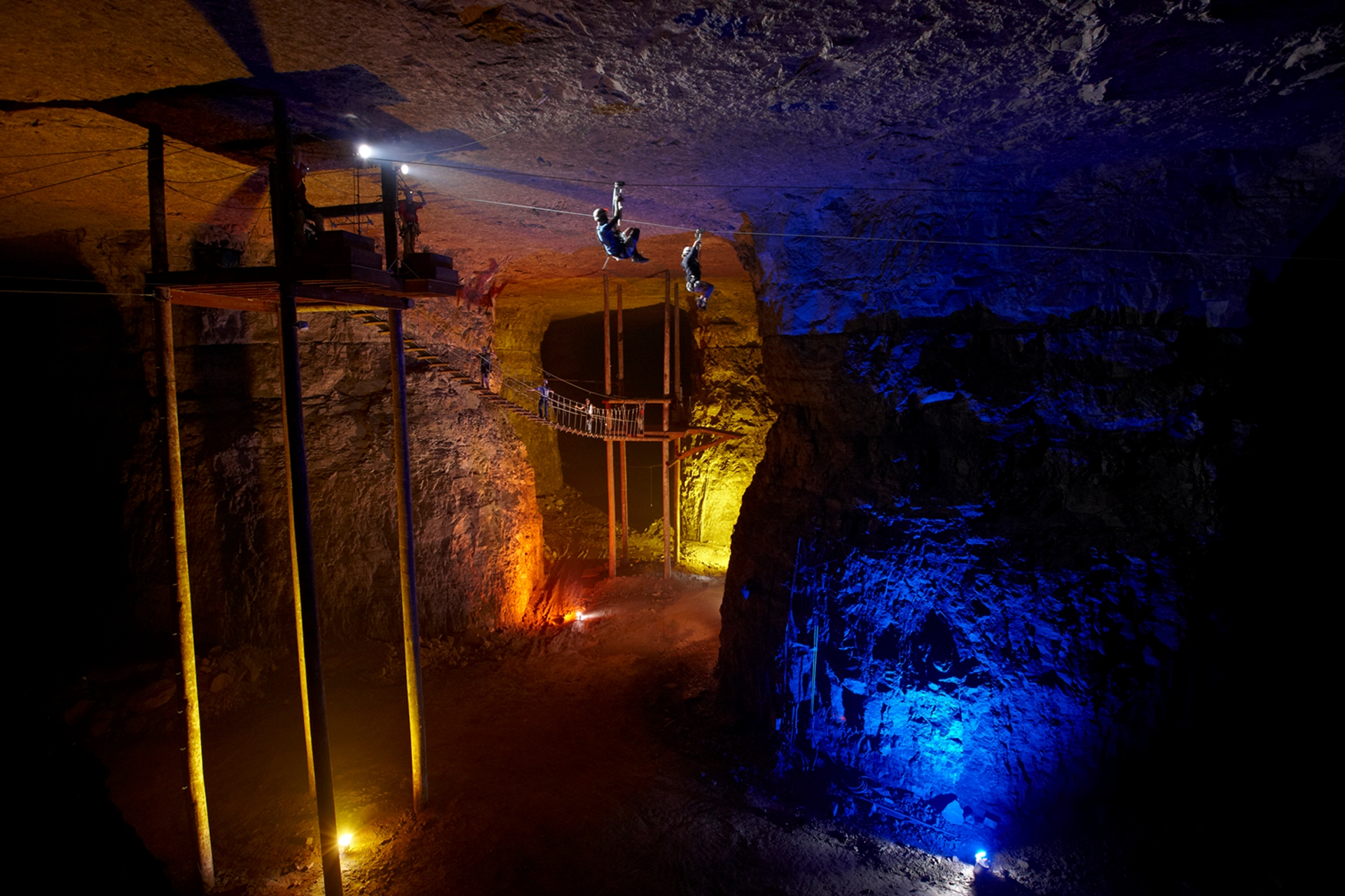 Mega Cavern Zip lines Louisville Kentucky with 2 men taking the plunge in the coloured light caves