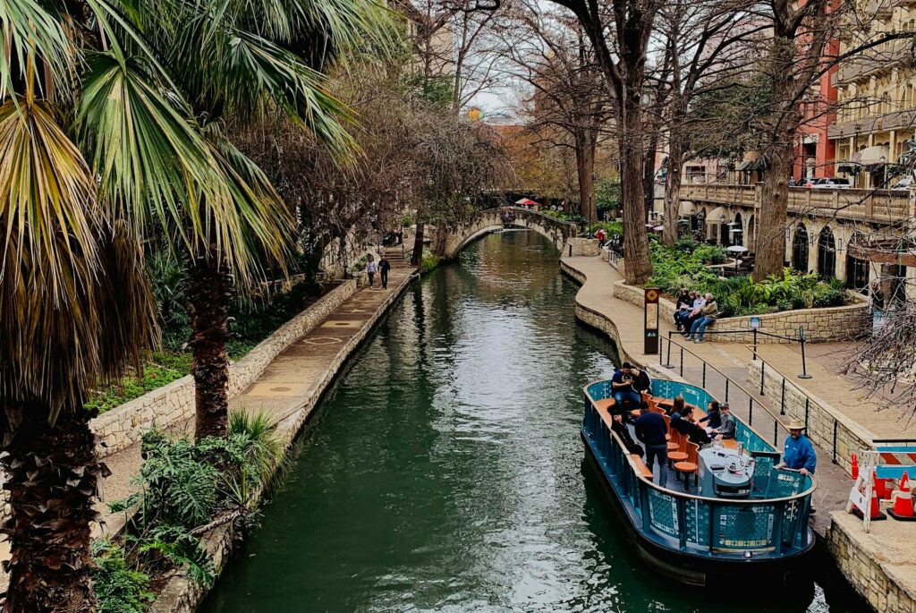 San Antonio River Walk in a blue boat surrounded by historic buildings