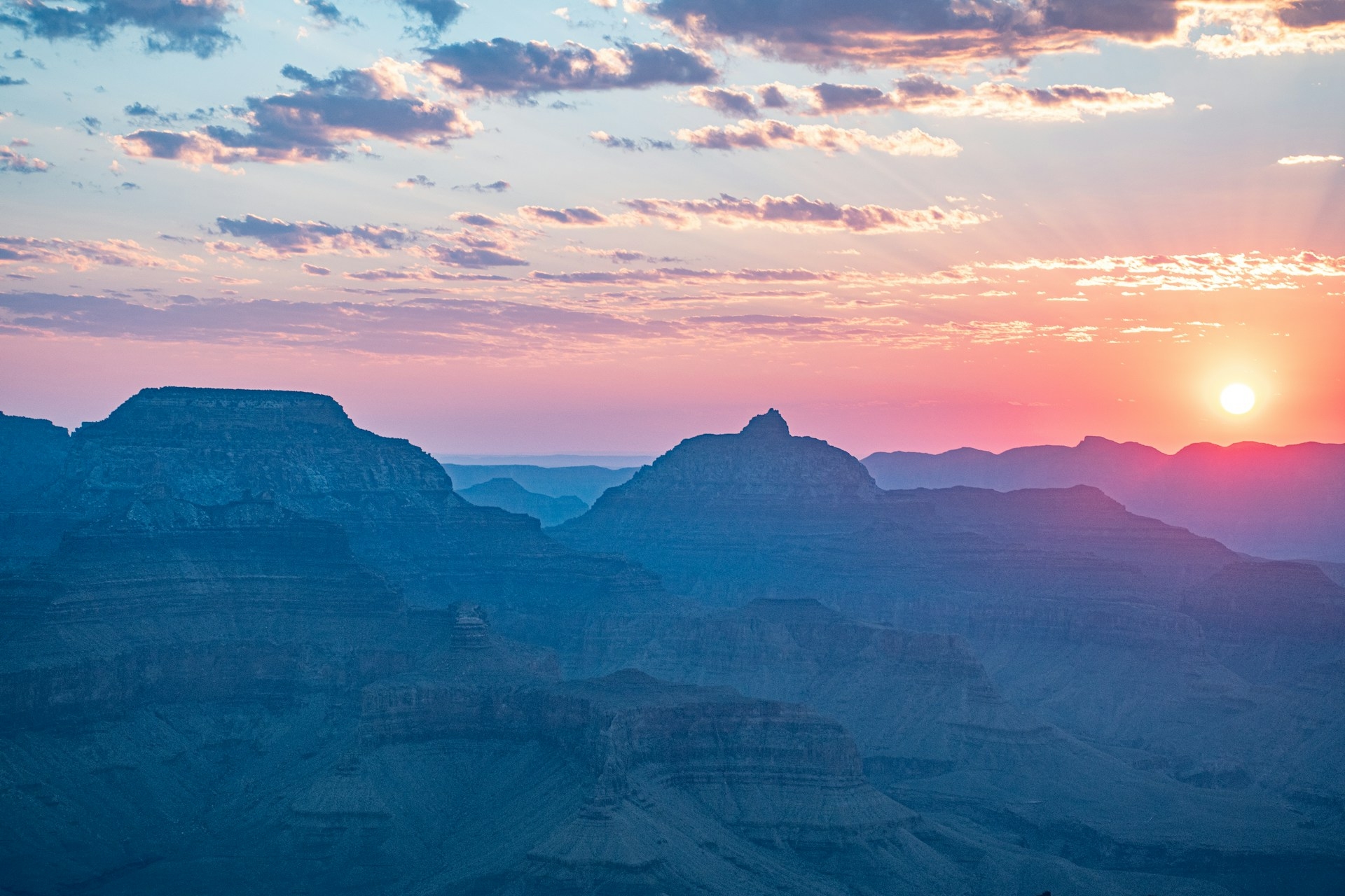 Sunset in the Grand Canyon showing the layers of rock in amongst the peaks