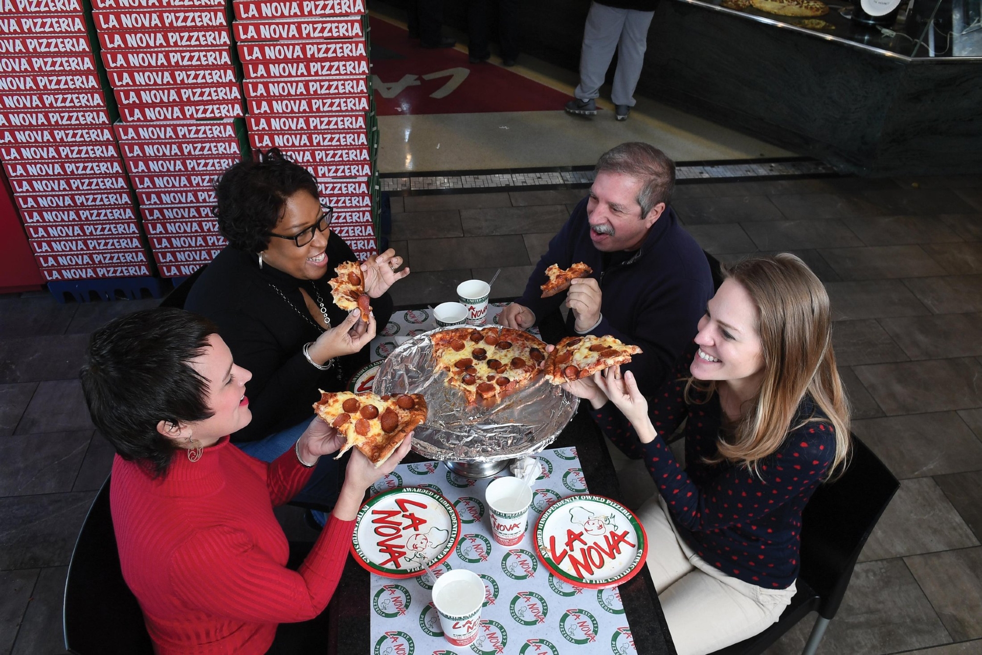Buffalo La Nova pizzeria NY State with people enjoying a slice of pizza