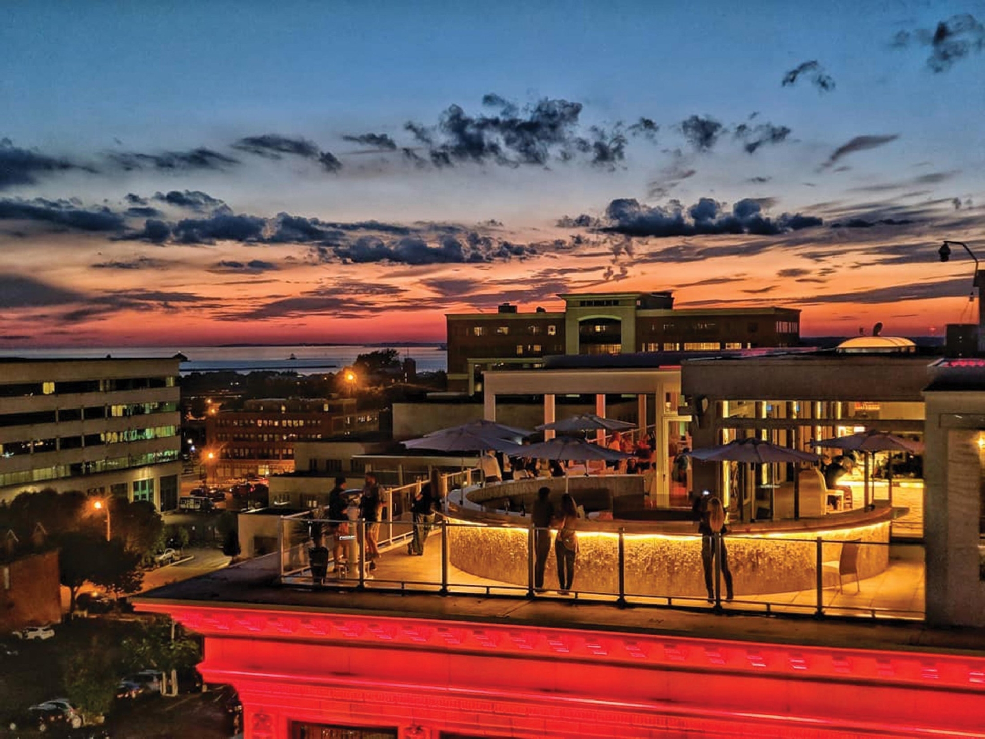 Curtiss Hotel in Buffalo on the sunset night showing the rooftop bar with people enjoying the evening